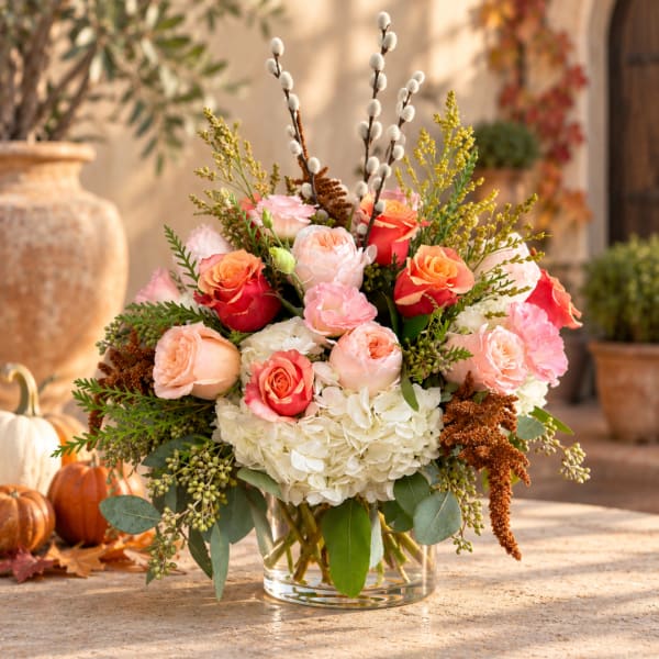 Mixed bouquet of roses and hydrangeas in a clear glass vase
