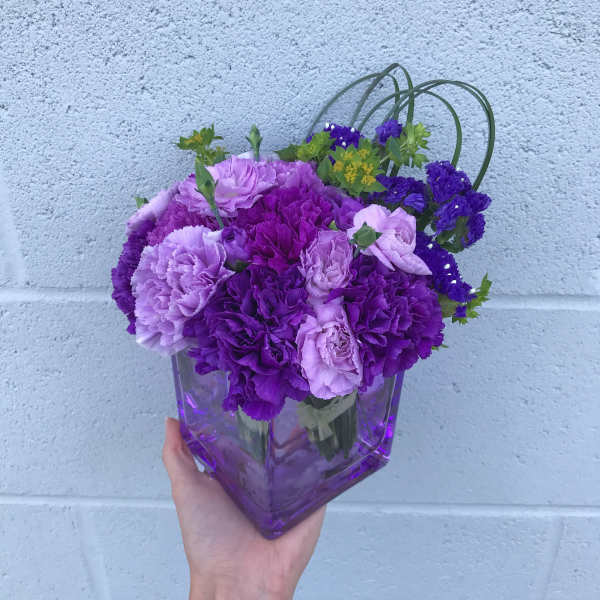 Purple and lavender carnations in a purple glass vase