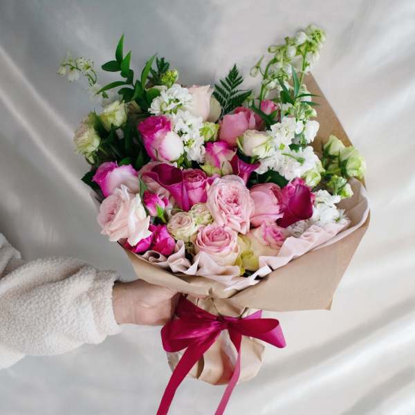 Handheld bouquet of pink and white roses with calla lilies and white blooms