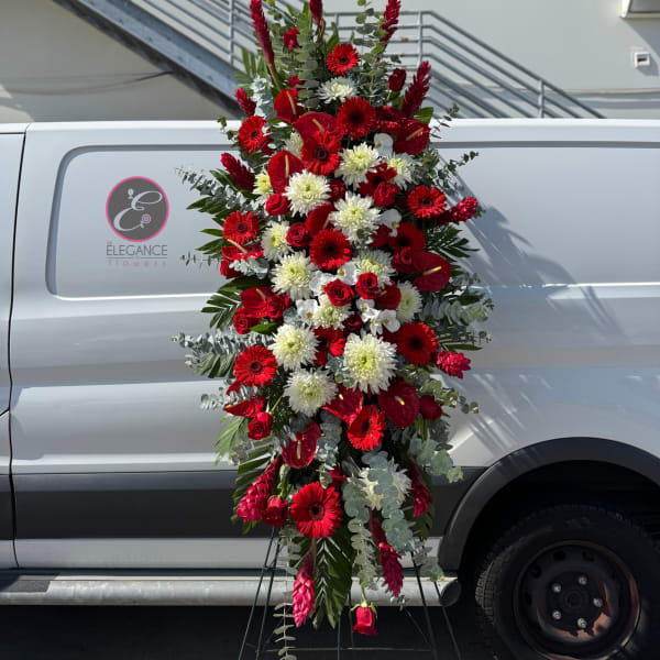 Tall red and white floral standing spray on an easel