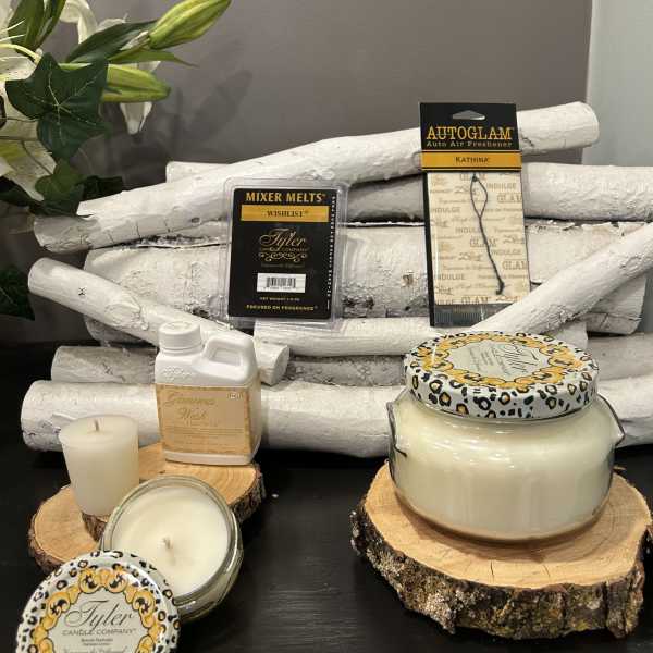 Assorted candles and fragrance products arranged on wood slices