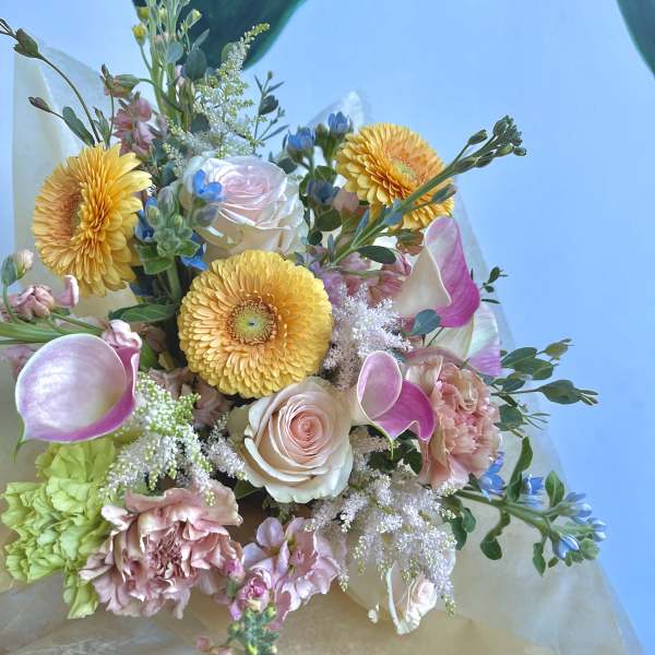 Bouquet of yellow gerbera daisies, pink roses, and calla lilies