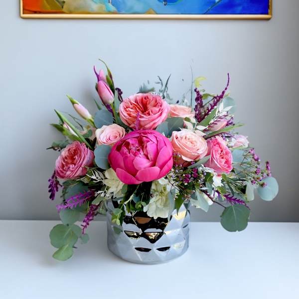 Pink and blush roses in a silver vase with eucalyptus