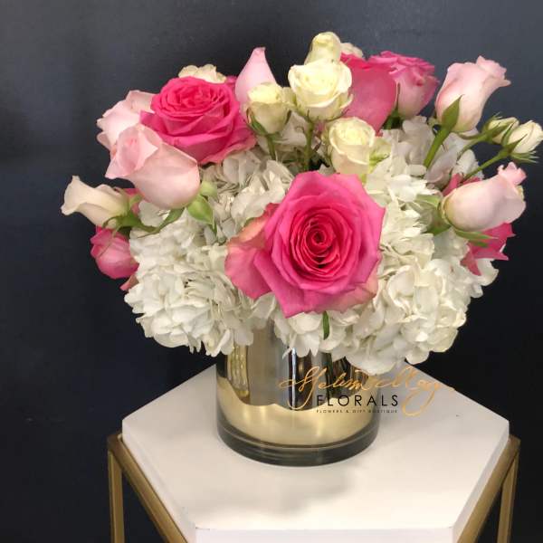 Pink and white roses arranged in a glass vase