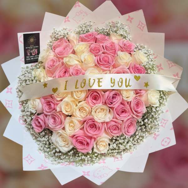 Bouquet of pink and cream roses with a ribbon reading I LOVE YOU