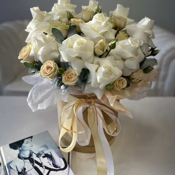 Bouquet of white roses and cream spray roses in a ribbon-tied box