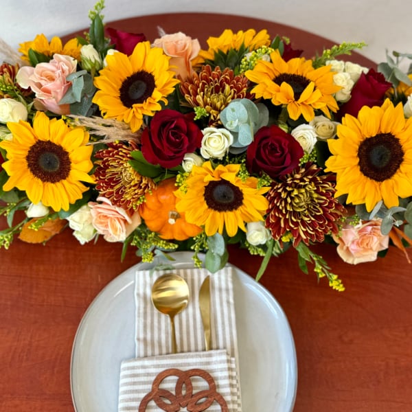 Mixed bouquet with sunflowers, roses, and chrysanthemums on a table setting