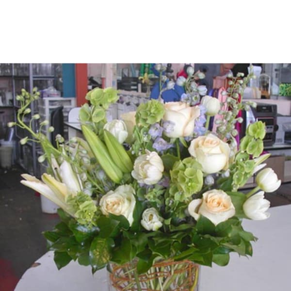 White and cream floral arrangement in a square glass vase