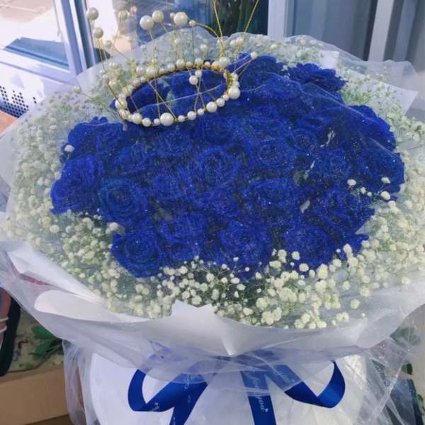 Blue rose bouquet with white baby's breath and a pearl crown