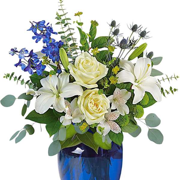 White roses and lilies in a blue glass vase with blue flowers