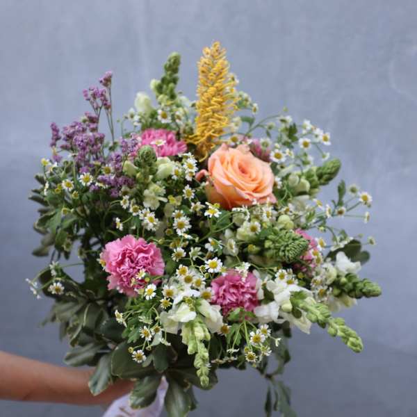Hand-tied bouquet of mixed pink, peach, white, and yellow flowers