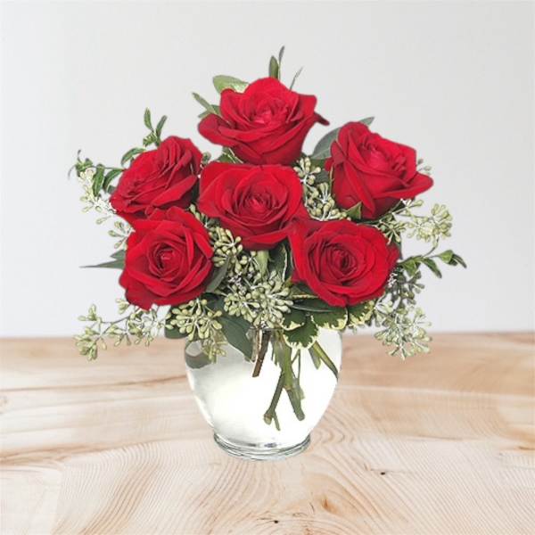 Red roses arranged in a clear glass vase