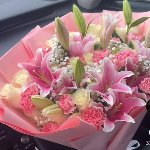 Pink bouquet of lilies, roses, and carnations wrapped in pink paper