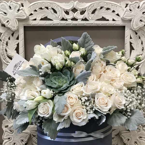 Cream roses and white blooms in a navy hatbox with silver ribbon