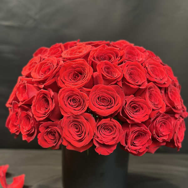 Round bouquet of red roses in a black vase