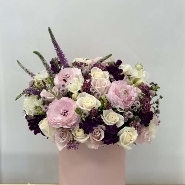 Pink and white floral arrangement in a blush cylindrical box