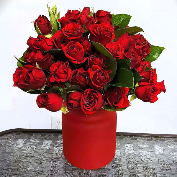 Red rose bouquet in a red cylindrical vase