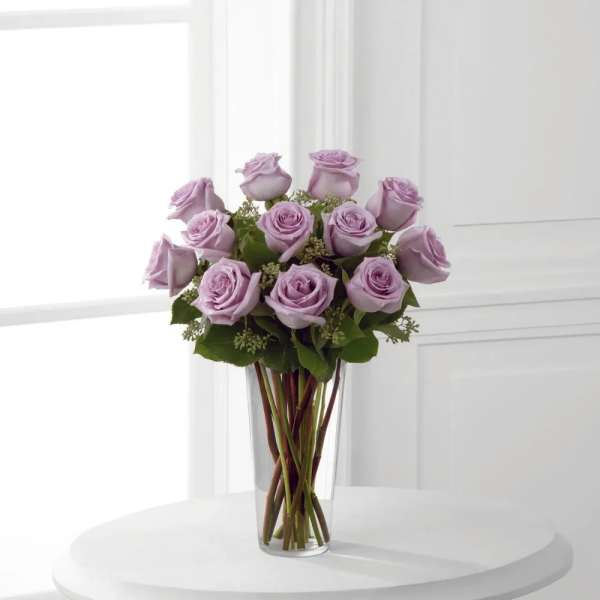 Lavender roses arranged in a clear glass vase