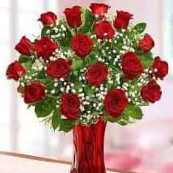 Bouquet of red roses in a red glass vase