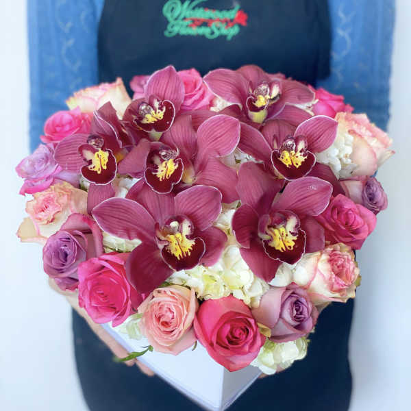 Heart-shaped box of pink roses and burgundy orchids