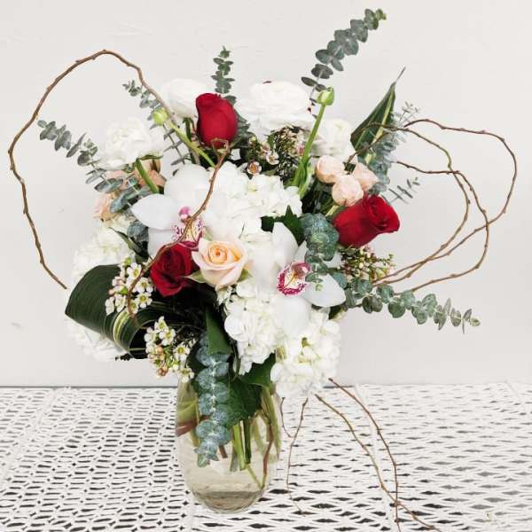 Bouquet of red and white flowers in a clear glass vase