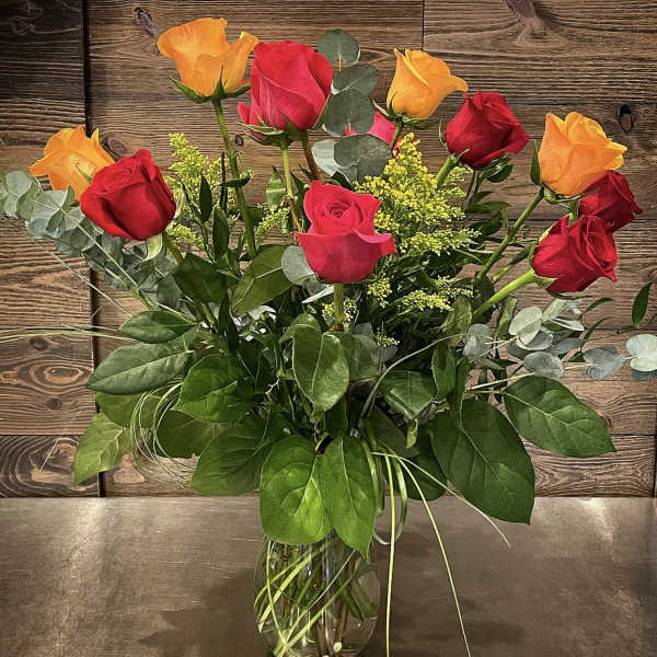 Bouquet of red and orange roses in a clear glass vase