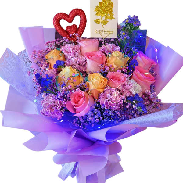 Bouquet of pink and yellow roses with purple filler and a red heart topper