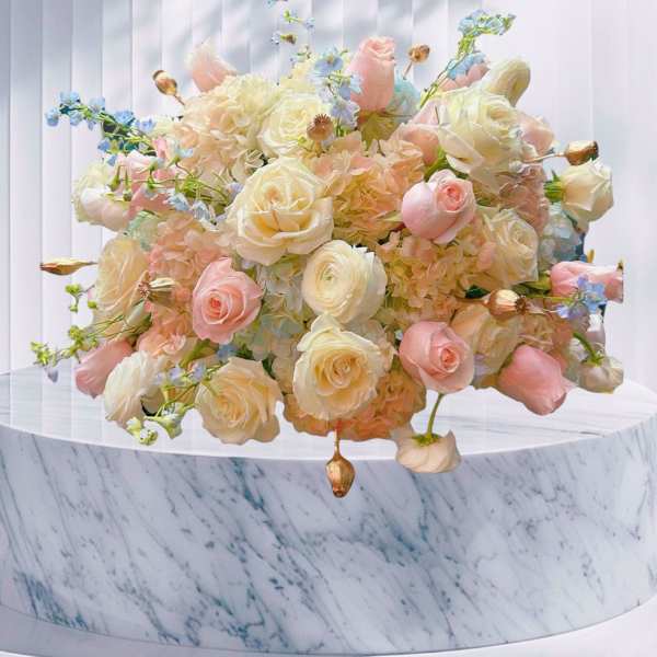 Pastel bouquet of roses and hydrangeas on a marble pedestal