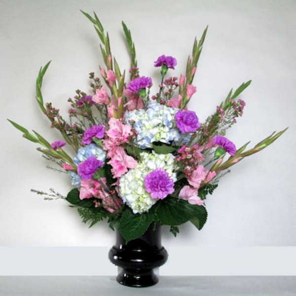 Pink and purple floral arrangement in a black vase