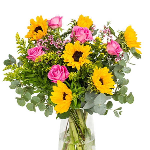 Bouquet of pink roses and yellow sunflowers in a clear glass vase
