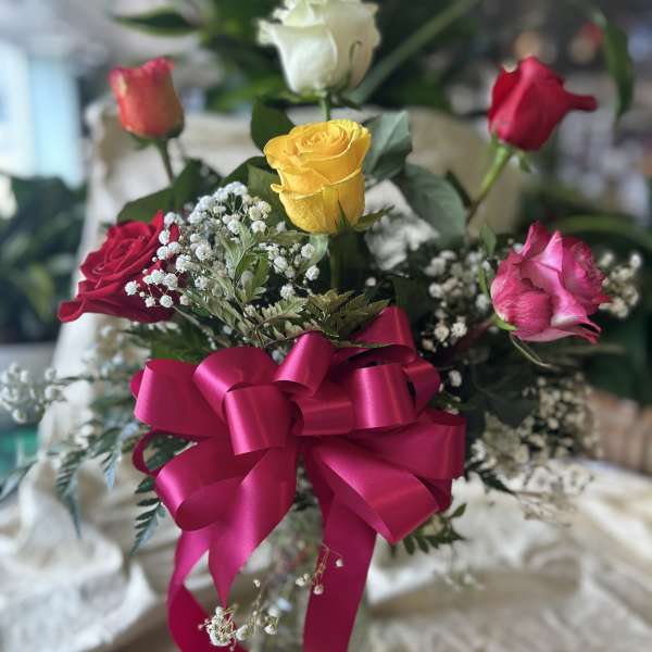 Bouquet of multicolored roses with a pink ribbon bow