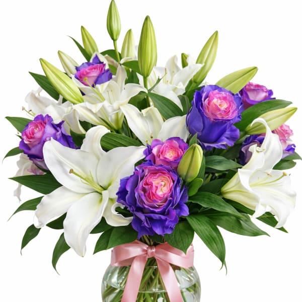 Bouquet of white lilies and purple-pink roses in a glass vase