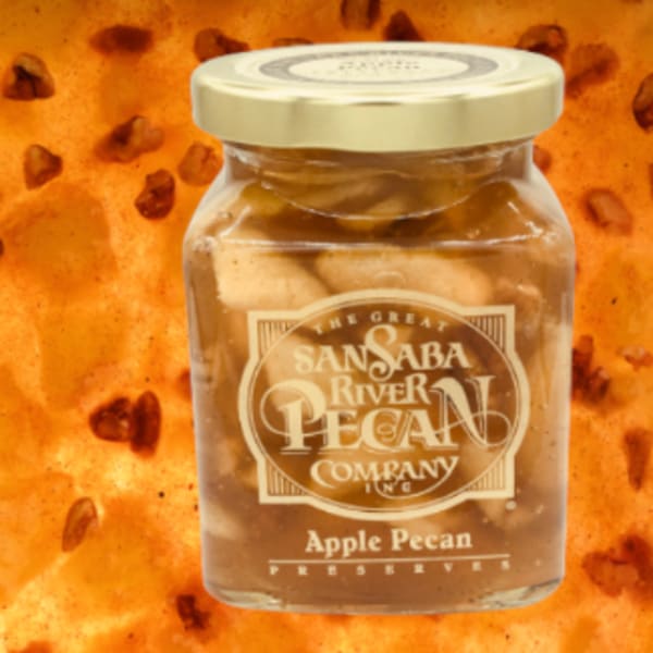Jar of apple pecan preserves on an orange patterned background