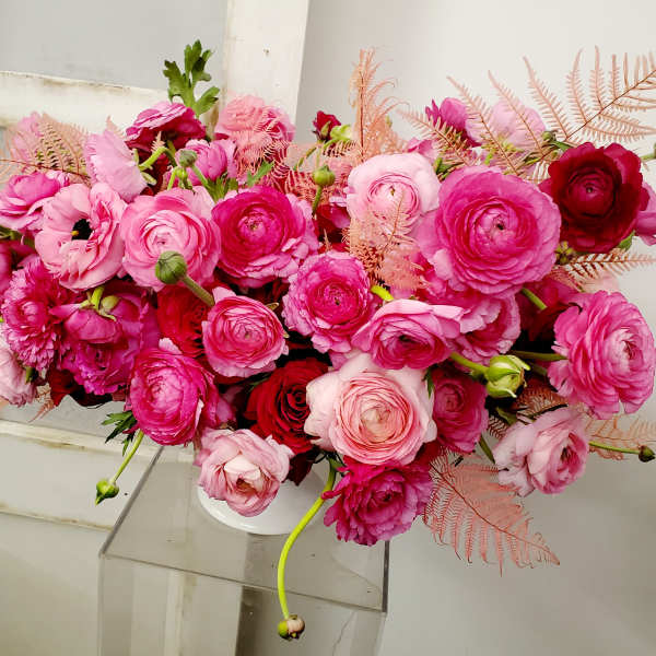 Pink and red ranunculus bouquet in a white vase