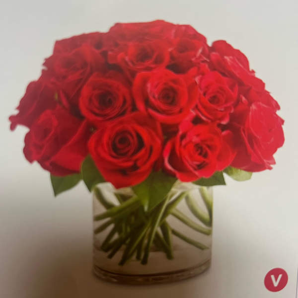 Red roses arranged in a clear glass vase