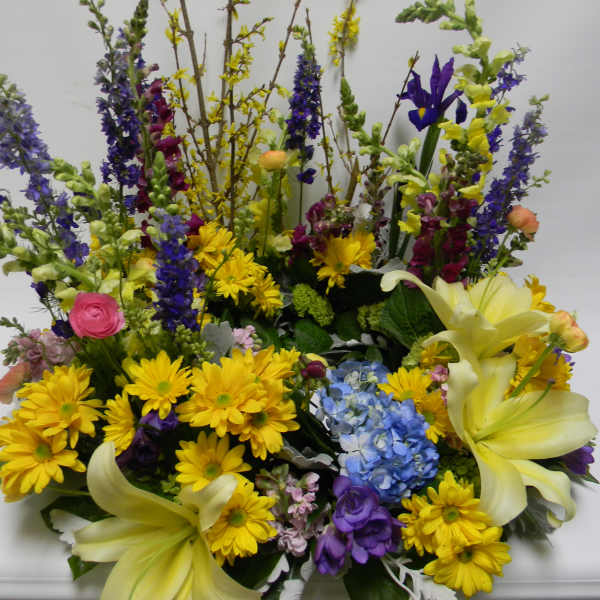 Large mixed bouquet with yellow lilies, daisies, and blue flowers