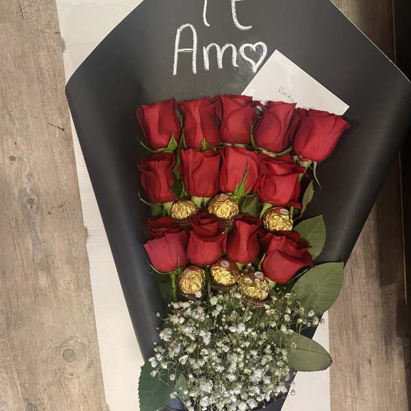 Bouquet of red roses with gold-wrapped chocolates and baby's breath