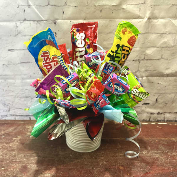Candy bouquet in a white ribbed container with colorful ribbons
