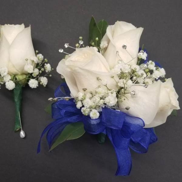 White rose boutonnieres with baby's breath and blue ribbon