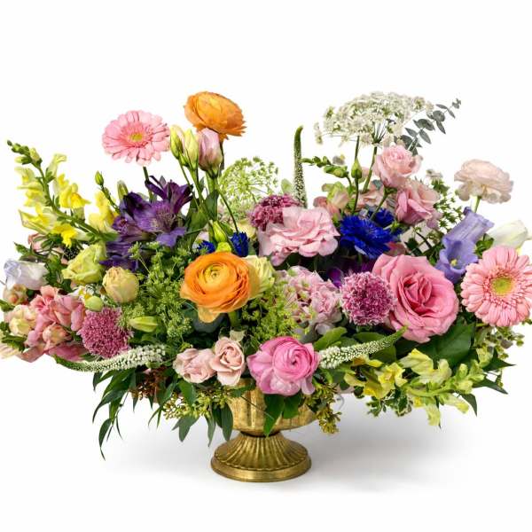 Colorful mixed flower arrangement in a gold pedestal vase