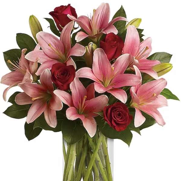 Pink lilies and red roses in a clear glass vase