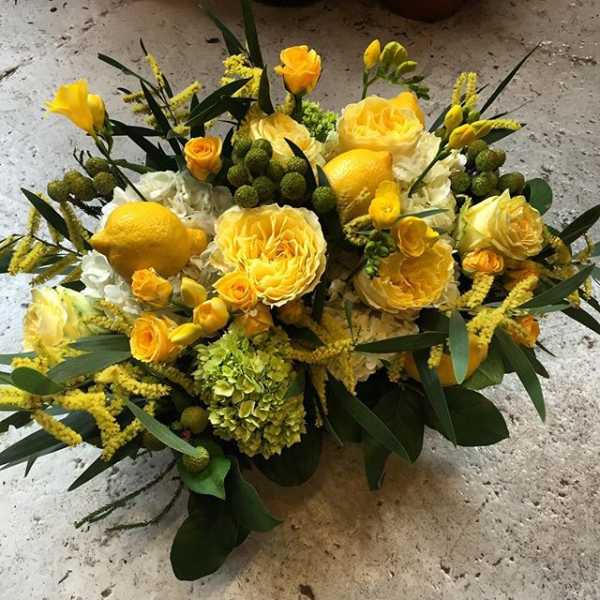 Yellow floral arrangement with roses and lemons