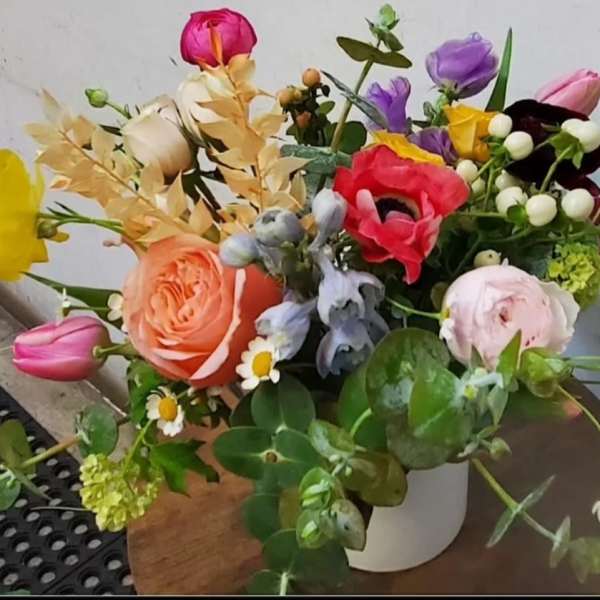 Mixed bouquet of colorful flowers in a white vase