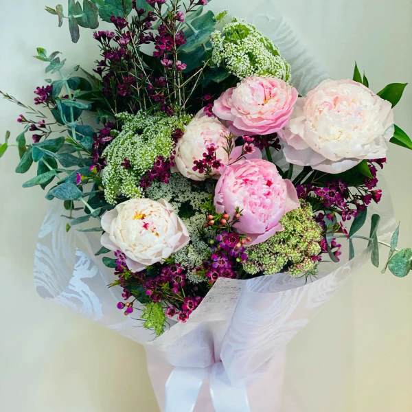 Bouquet of pink and white peonies with purple filler flowers