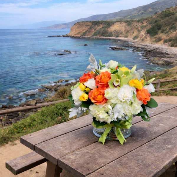 Bouquet of orange, white, and yellow flowers in a glass vase