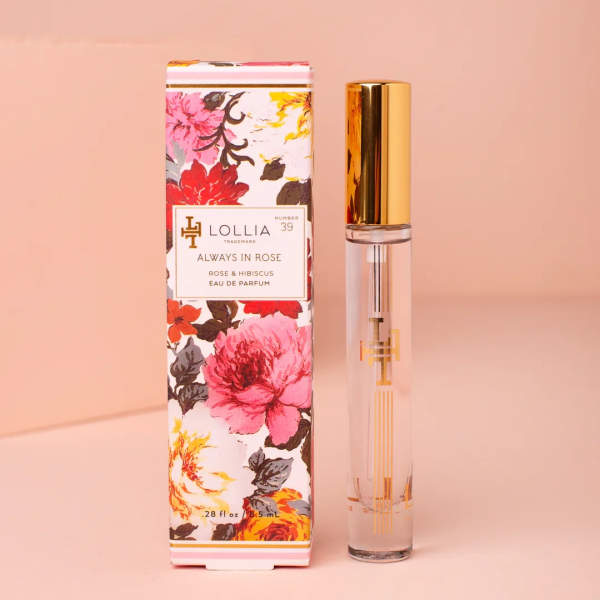 Floral-print perfume box beside a clear glass perfume bottle with a gold cap