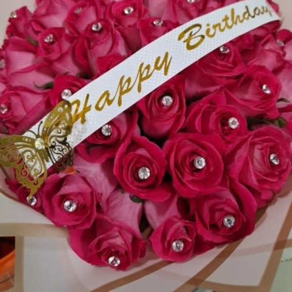 Bouquet of bright pink roses with a birthday ribbon