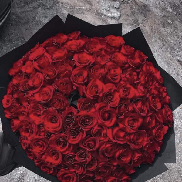 Large bouquet of red roses wrapped in black paper