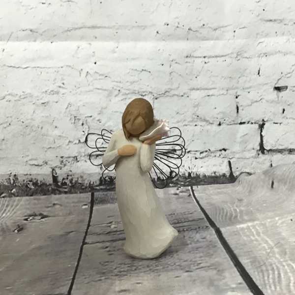 Small angel figurine in a white dress holding a trumpet