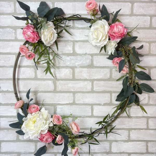 Floral wreath with pink and white roses on a metal hoop